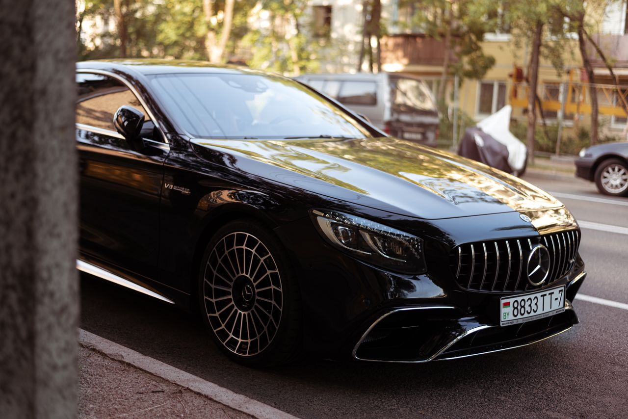 team-02 Luxury black car parked on an urban street, displaying elegance and sophistication.